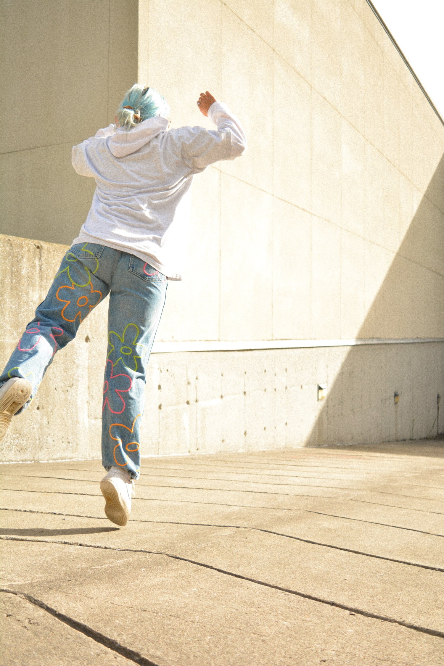 Motif de fleurs colorées sur jeans vintage bleu par l’artiste Caroline Auger de Drummondville, Québec.