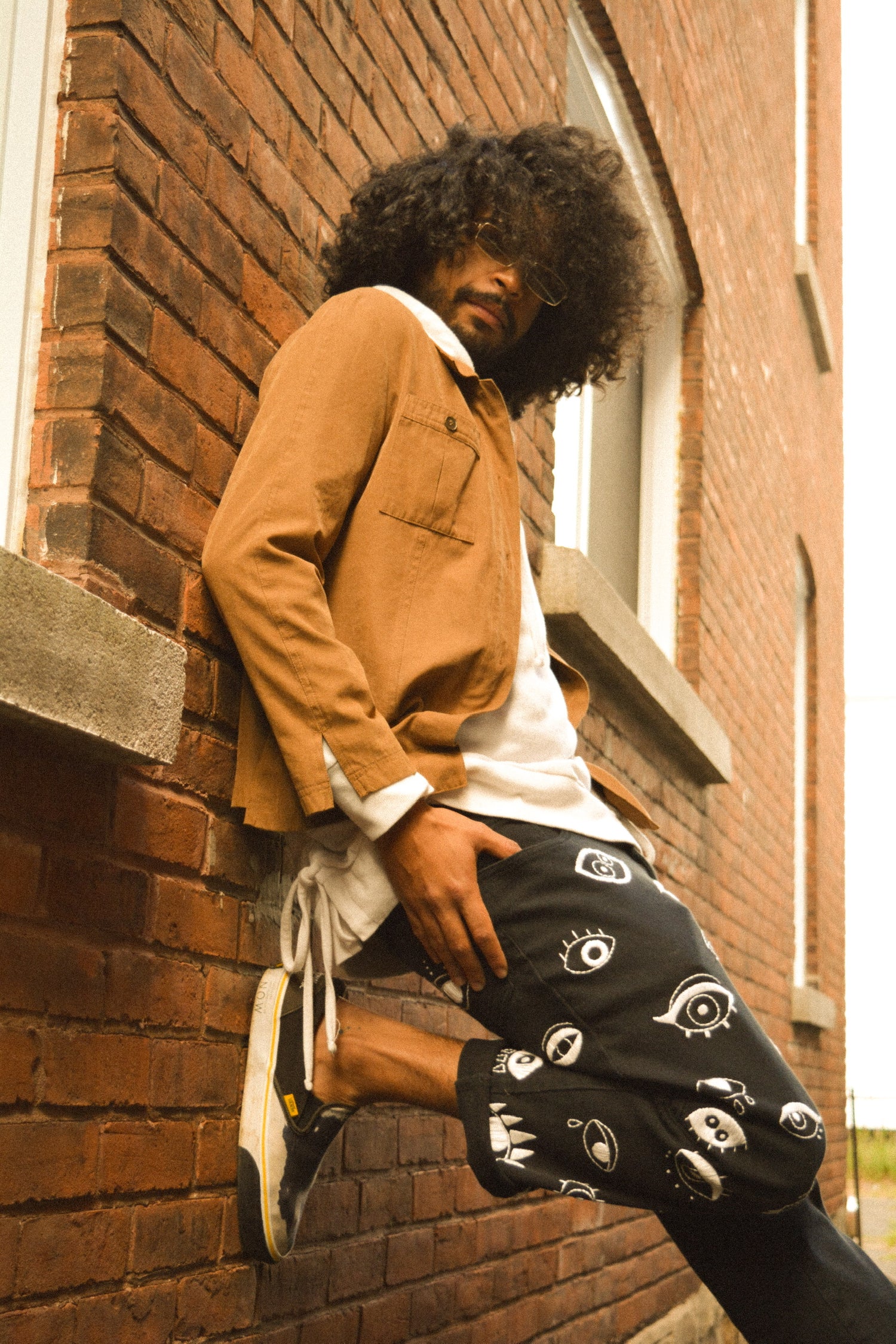 Pantalon noir à yeux blanc brodés à la main par l’artiste Caroline Auger de Drummondville, Québec.