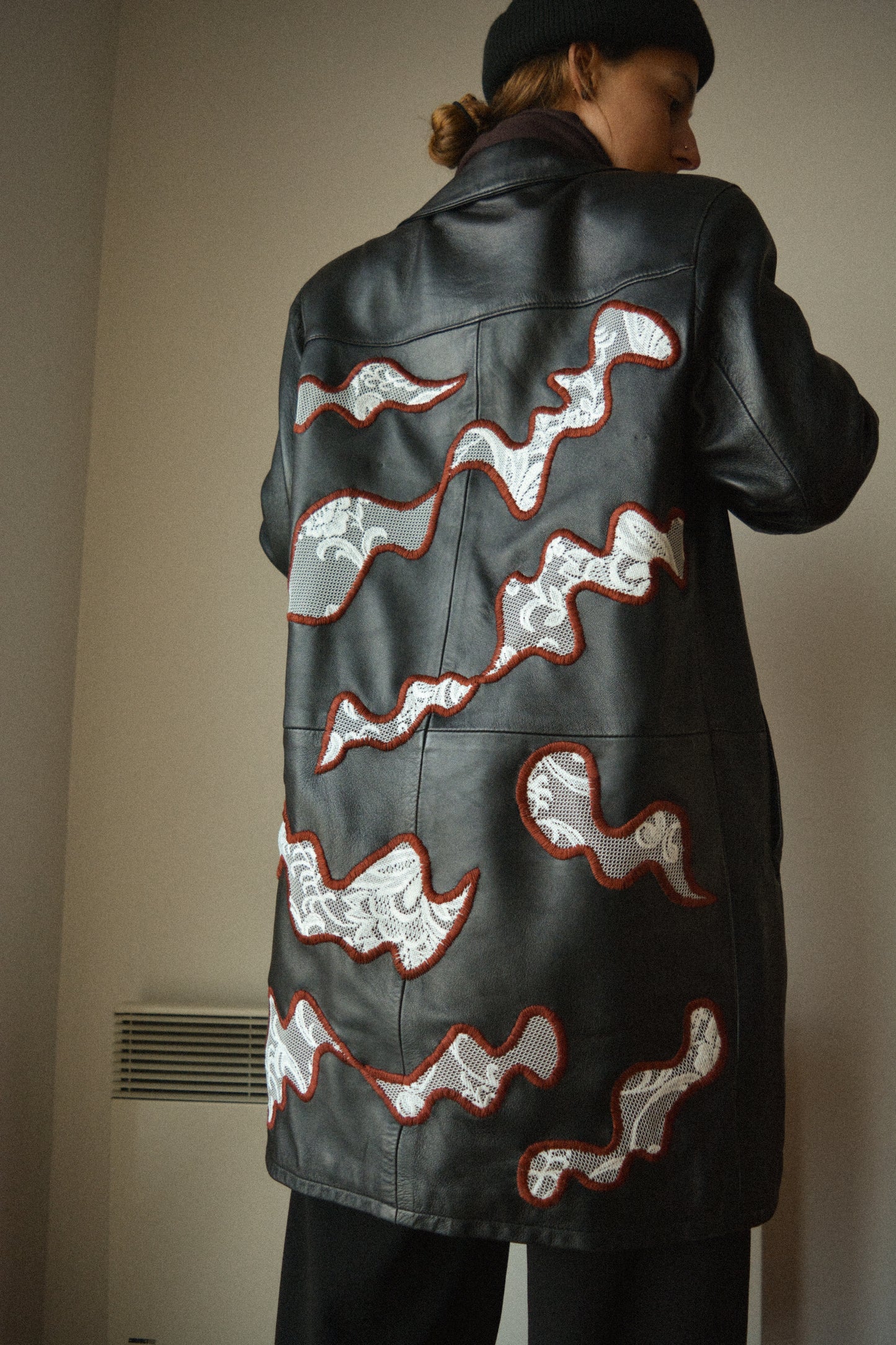Manteau vintage en cuir noir de seconde main avec patchs en dentelle recyclé et broderie fait à la main au Québec par l’artiste Caroline Auger