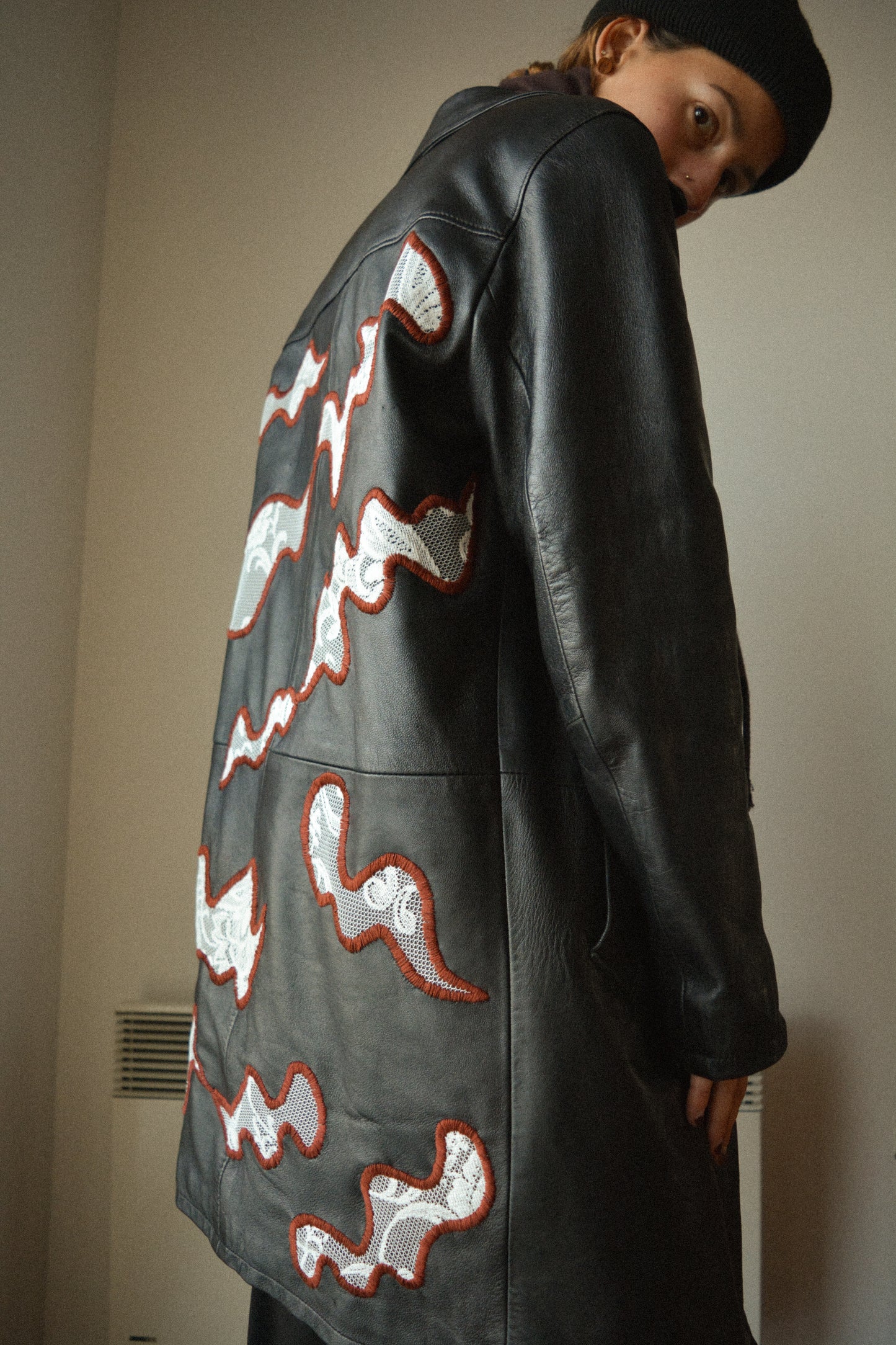 Manteau vintage en cuir noir de seconde main avec patchs en dentelle recyclé et broderie fait à la main au Québec par l’artiste Caroline Auger