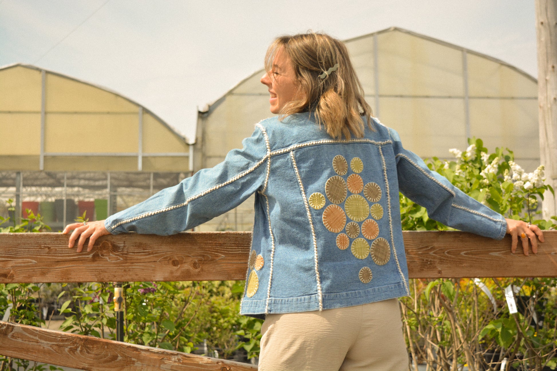 Veste vintage en jeans bleu à manches longues avec des patchs recyclées, des perles et de la laine qui ont été brodées à la main au Québec par l’artiste Caroline Auger
