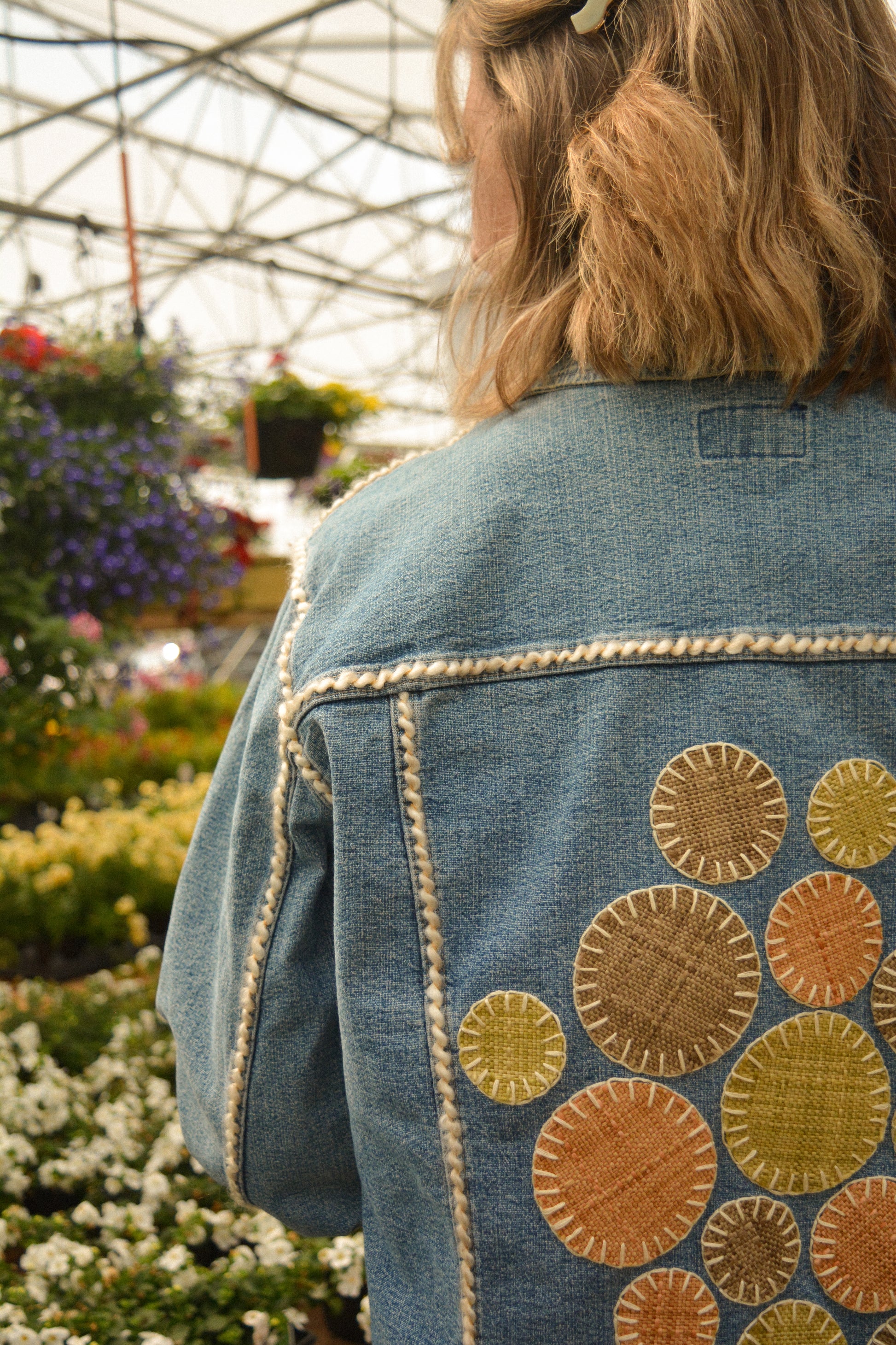 Veste vintage en jeans bleu à manches longues avec des patchs recyclées, des perles et de la laine qui ont été brodées à la main au Québec par l’artiste Caroline Auger