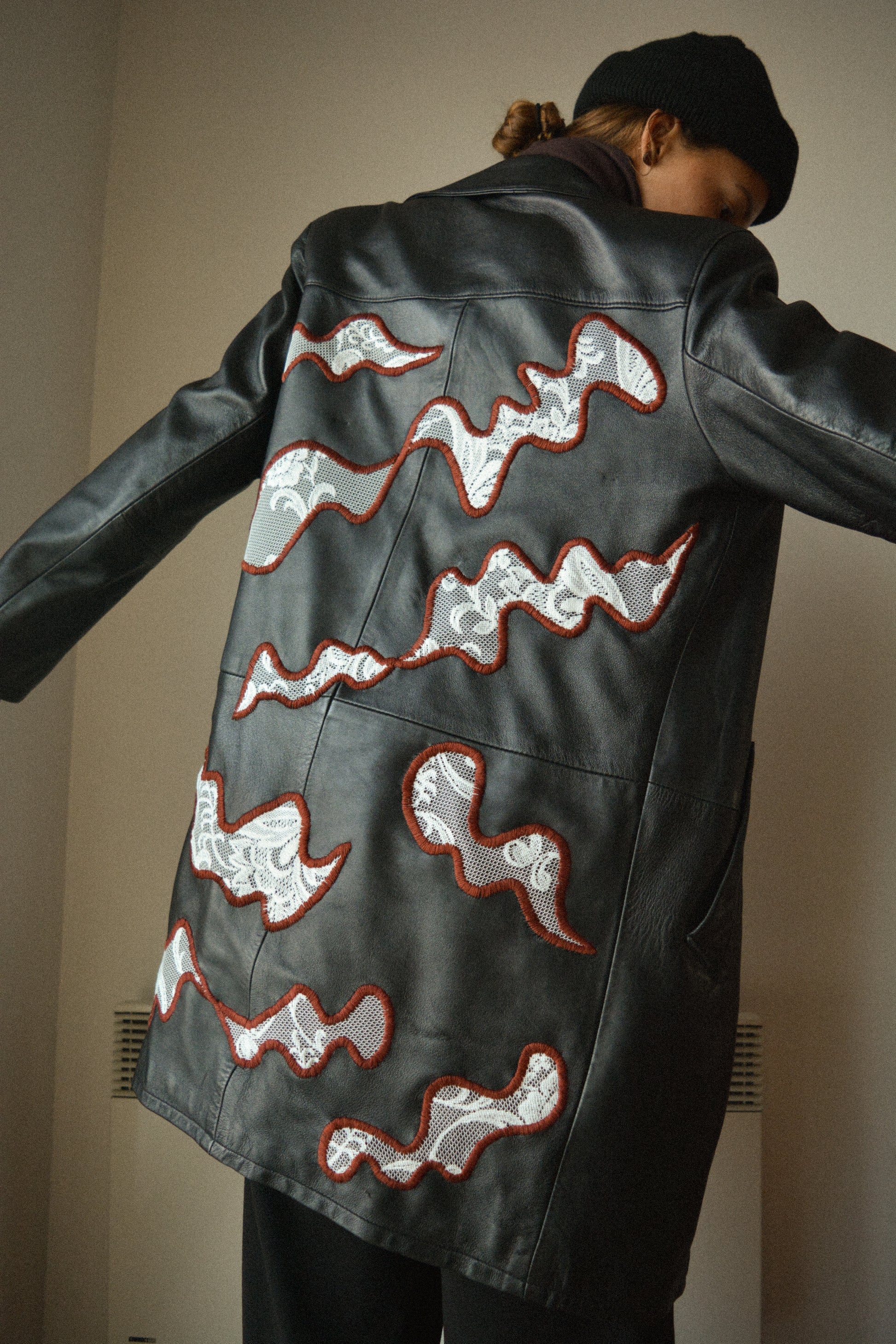 Manteau vintage en cuir noir de seconde main avec patchs en dentelle recyclé et broderie fait à la main au Québec par l’artiste Caroline Auger