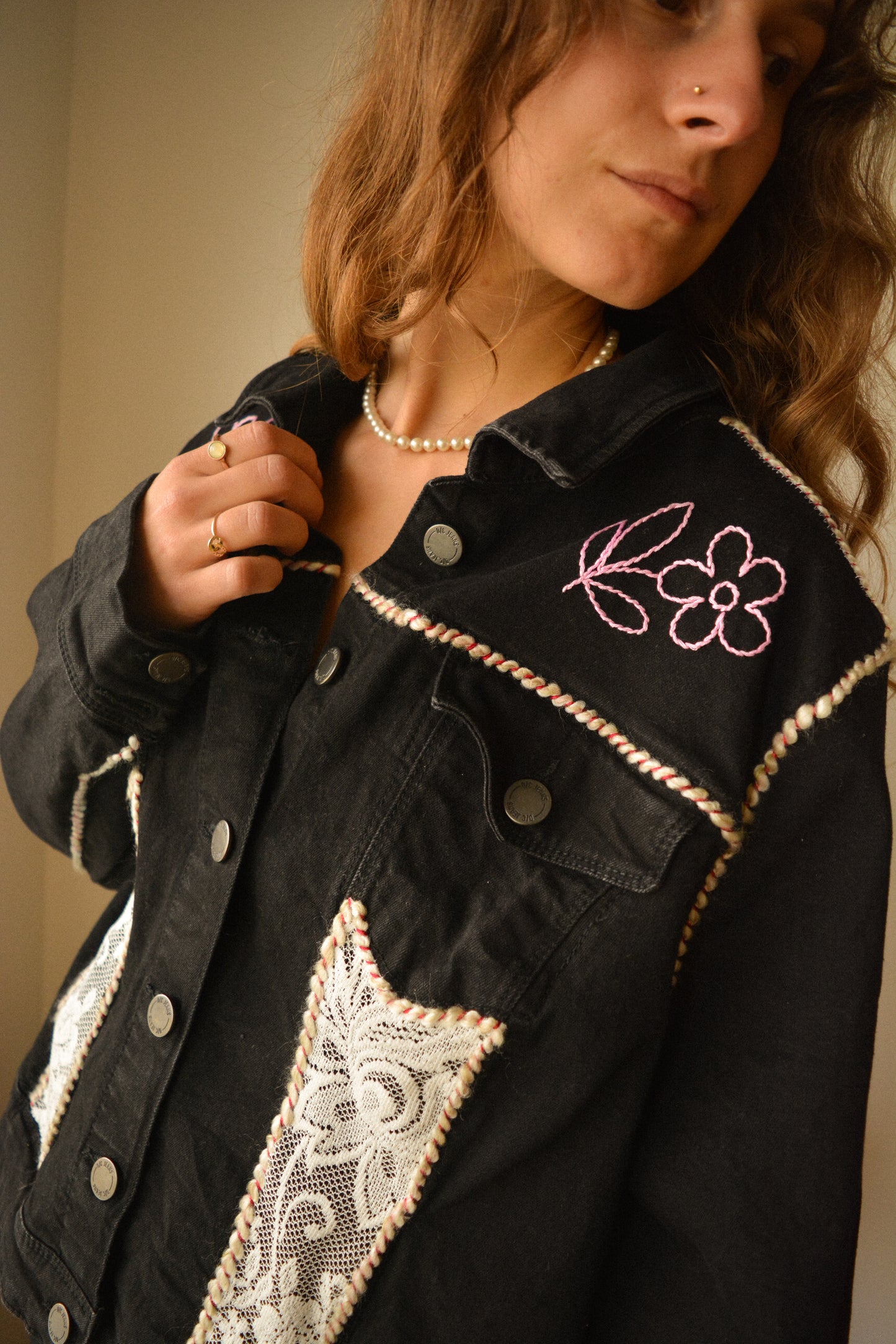 Veste en jeans noir vintage de seconde main à motifs de fleurs brodées, à laine brodés et à dentelle recyclée à la main au Québec par l’artiste et designer Caroline Auger