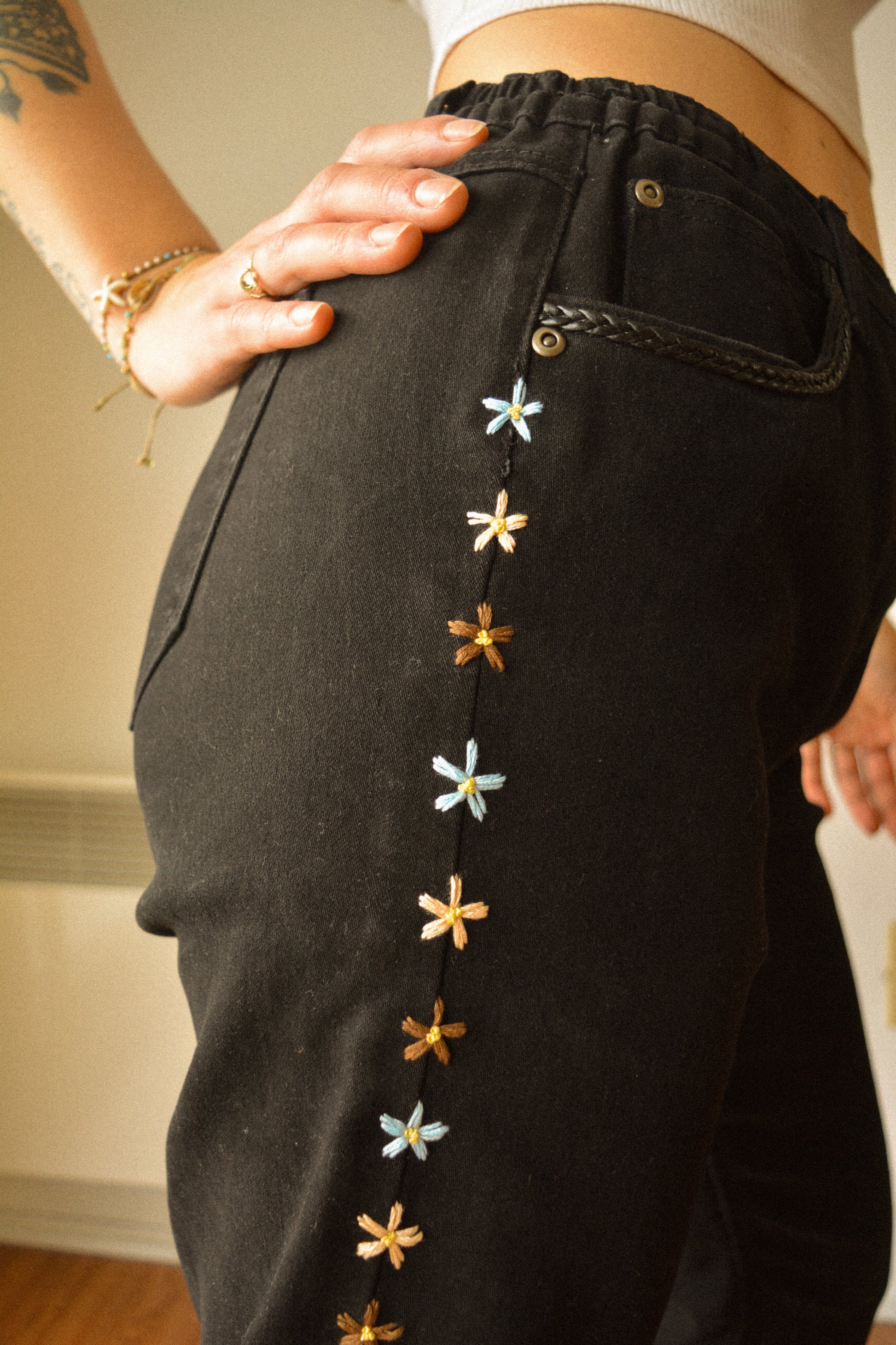 Pantalon vintage noir de seconde main à fleurs brodées à la main au Québec par l’artiste Caroline Auger