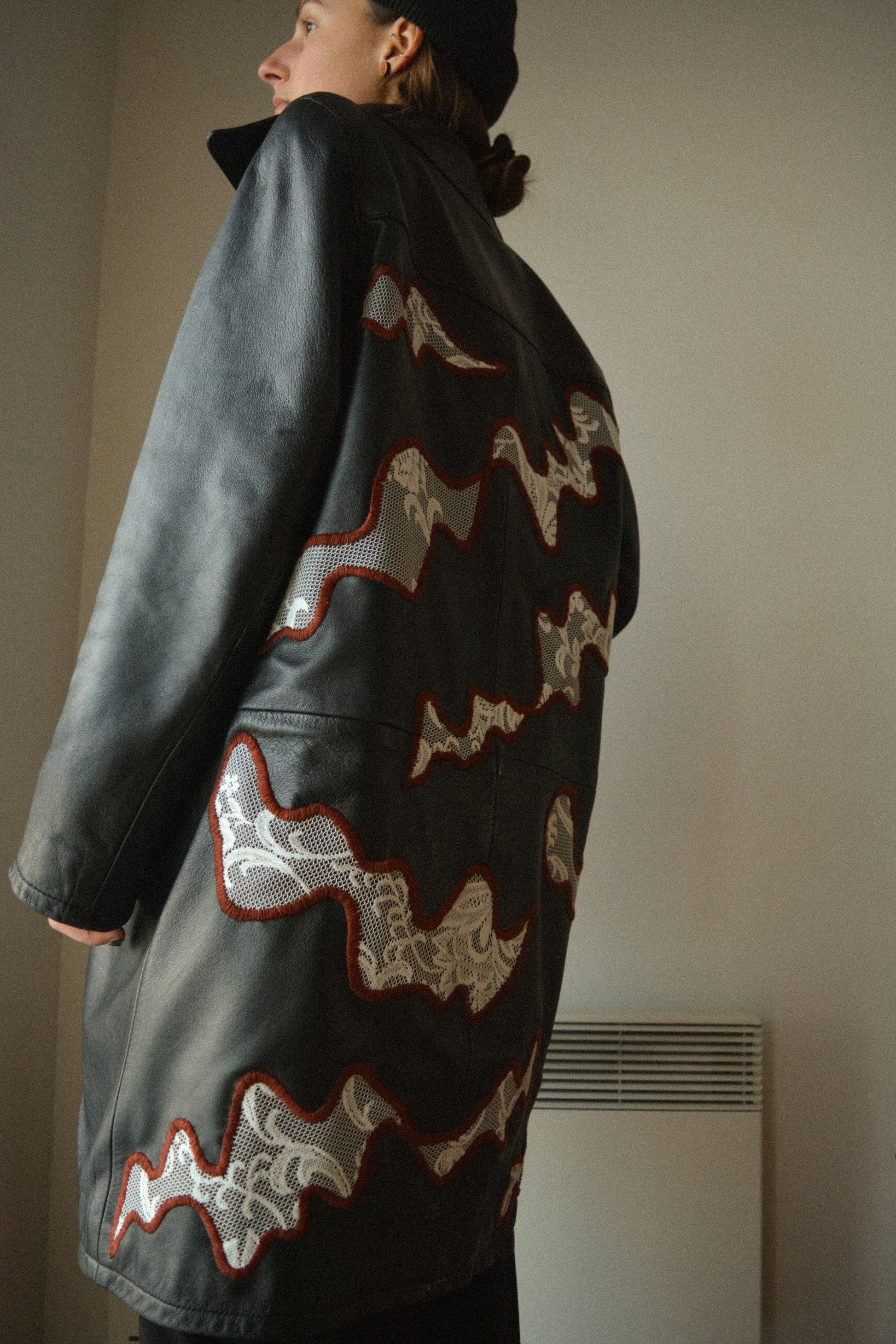 Manteau vintage en cuir noir de seconde main avec patchs en dentelle recyclé et broderie fait à la main au Québec par l’artiste Caroline Auger