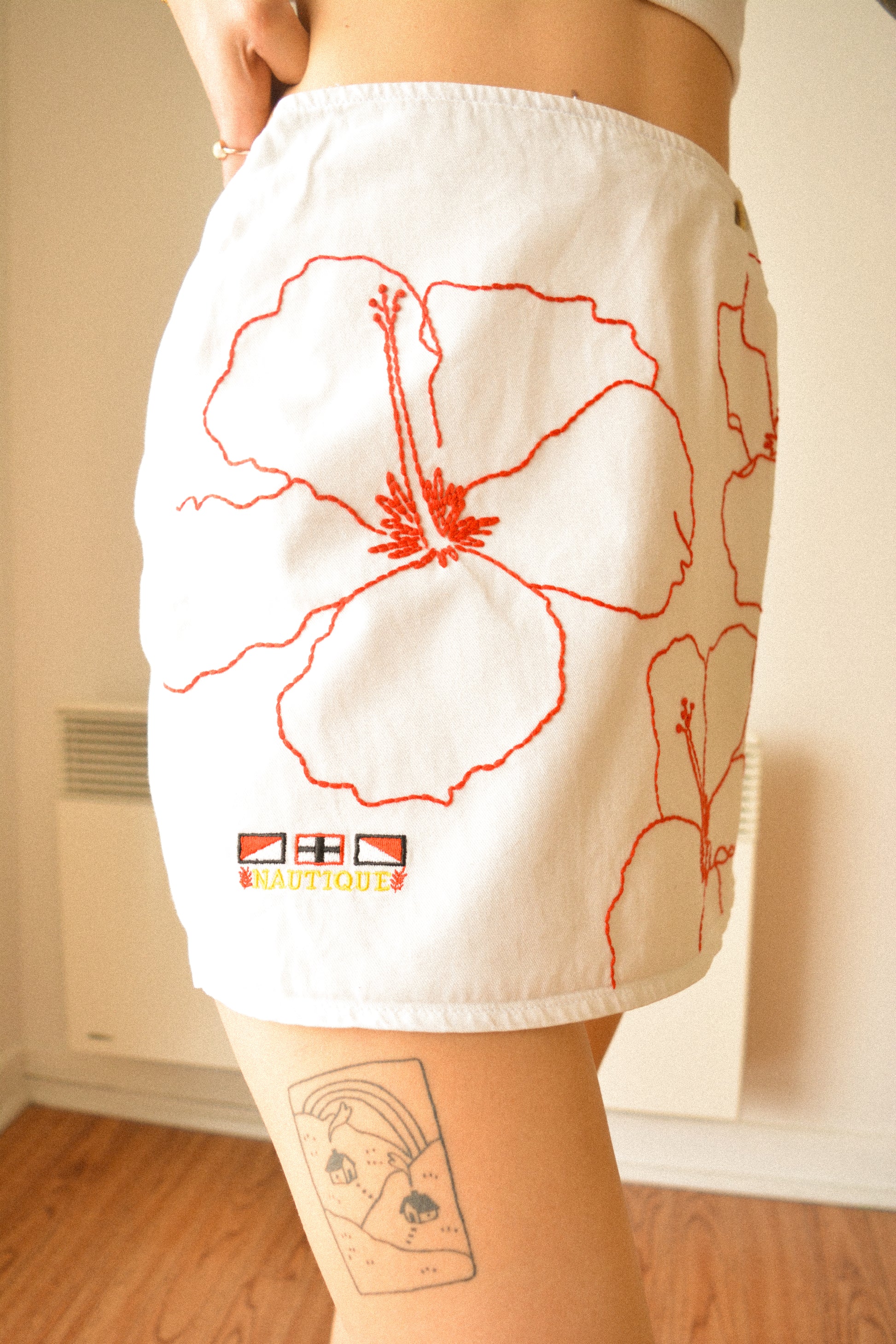 Jupe-Short vintage blanche à fleurs rouge brodées à la main au Québec par l’artiste Caroline Auger