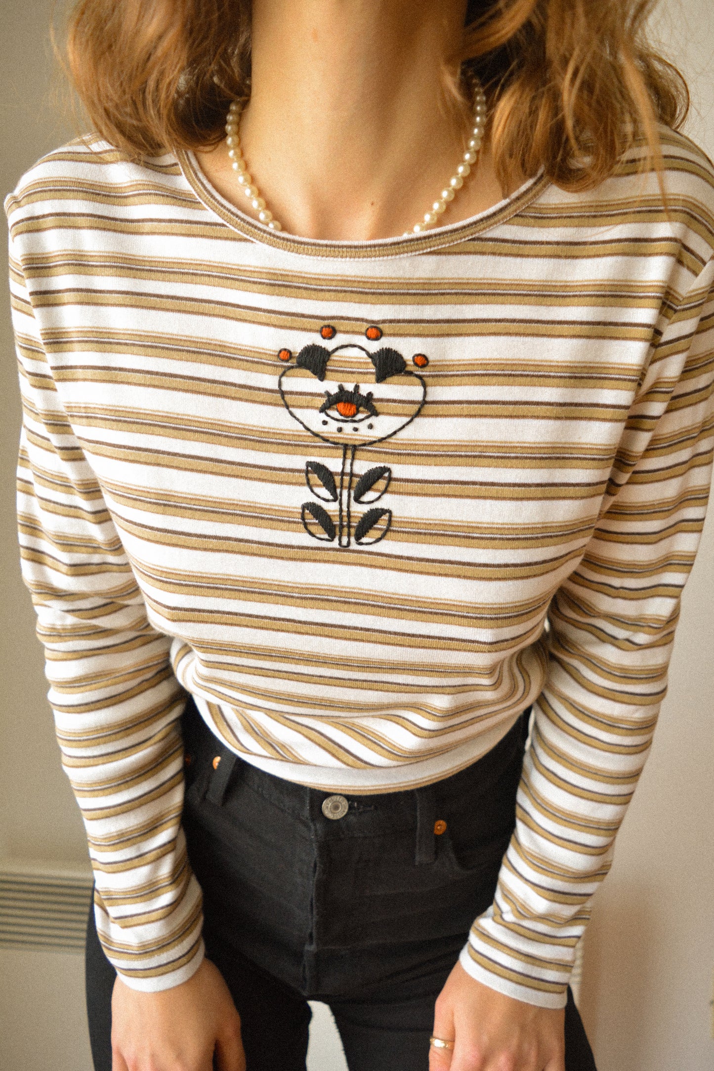 Chandail manches longues vintage rayé beige, blanc et brun à motif d’œil fleur old school brodé à la main au Québec par l’artiste Caroline Auger