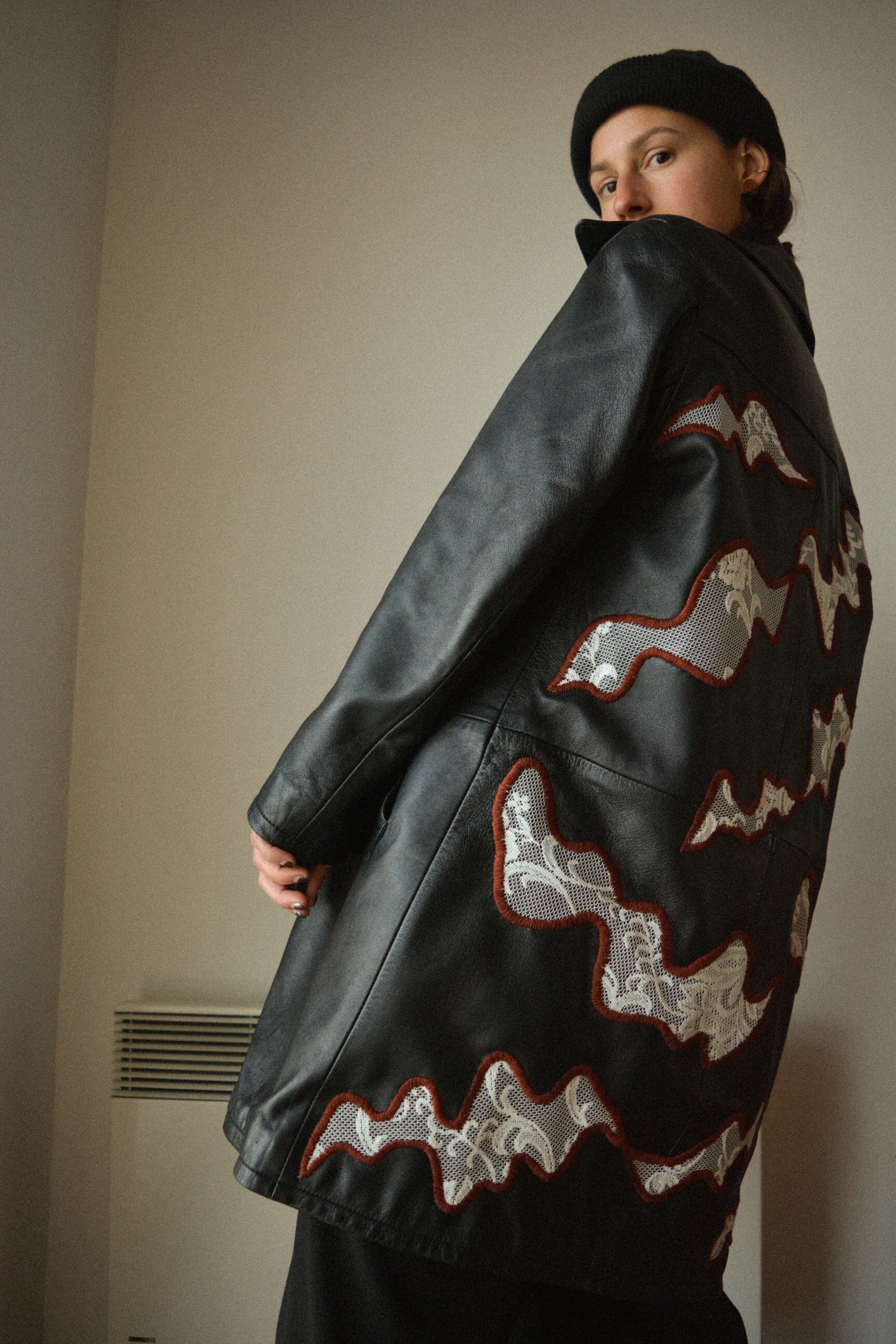 Manteau vintage en cuir noir de seconde main avec patchs en dentelle recyclé et broderie fait à la main au Québec par l’artiste Caroline Auger