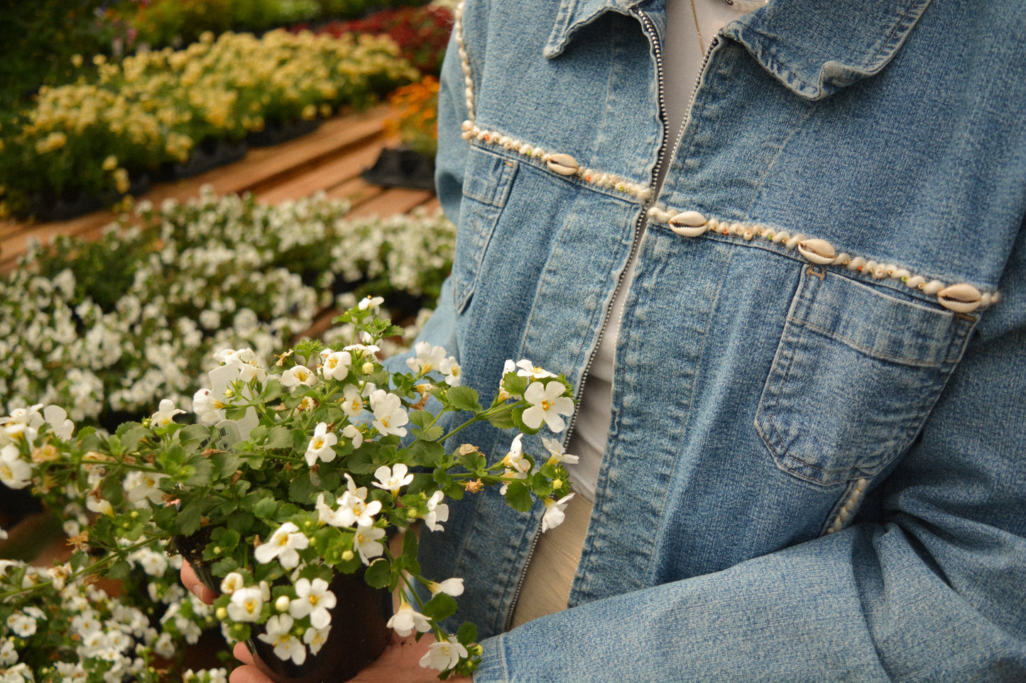 Veste vintage en jeans bleu à manches longues avec des patchs recyclées, des perles et de la laine qui ont été brodées à la main au Québec par l’artiste Caroline Auger