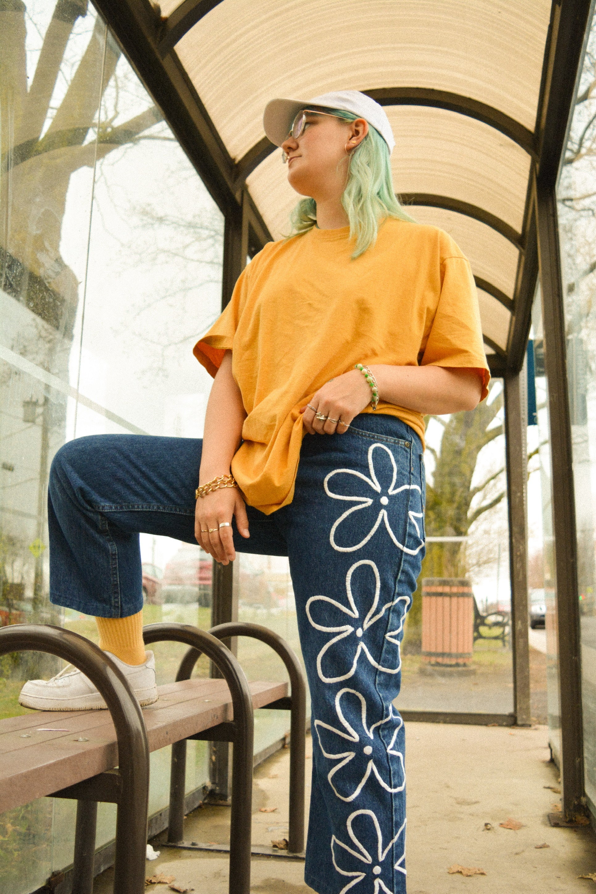 Pantalon de seconde main en jeans bleu foncé à fleurs blanches brodées à la main au Québec par l’artiste Caroline Auger