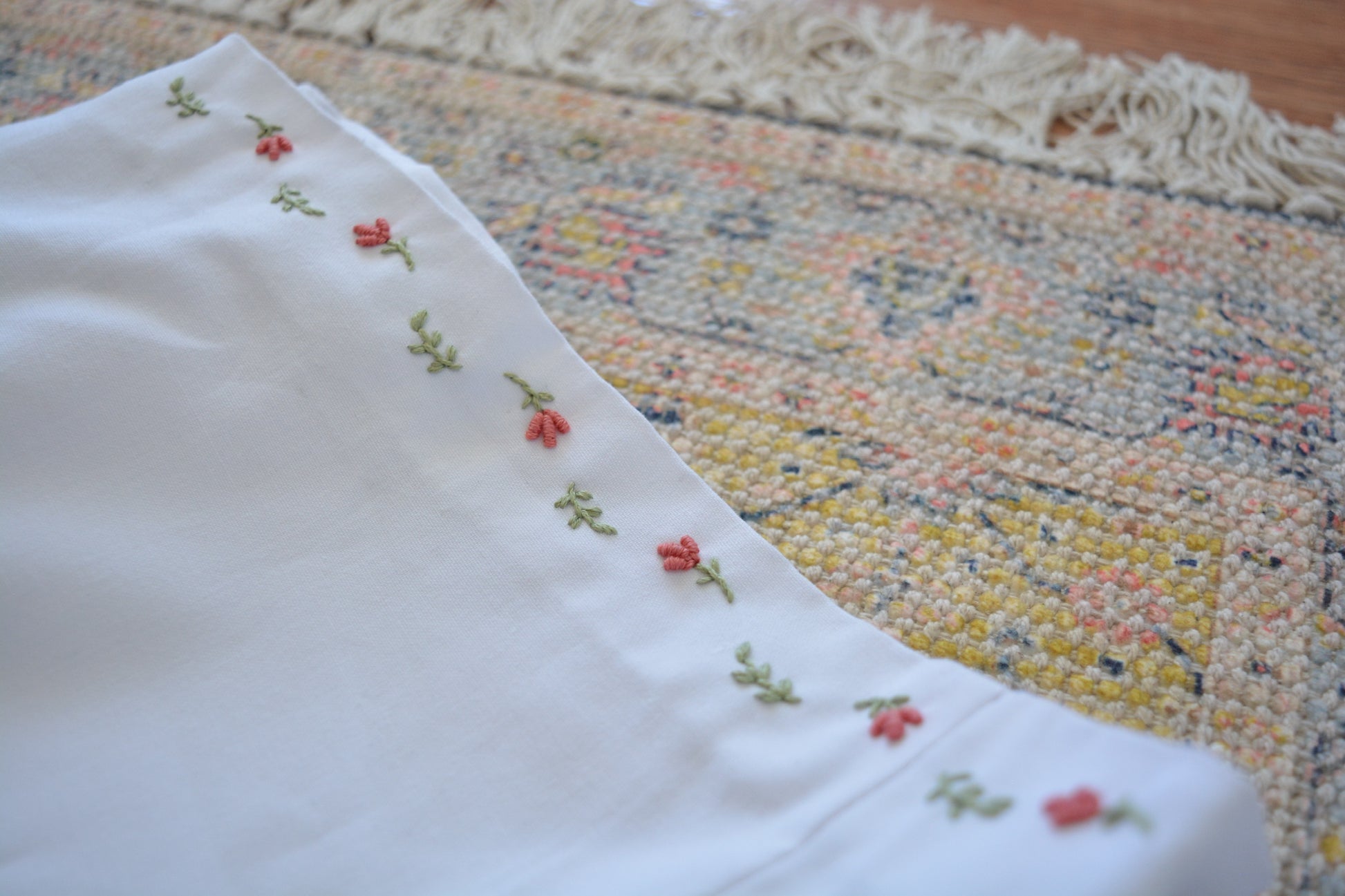 Jupe vintage blanche à mini fleurs et feuilles brodées à la main au Québec par l’artiste Caroline Auger de Drummondville.