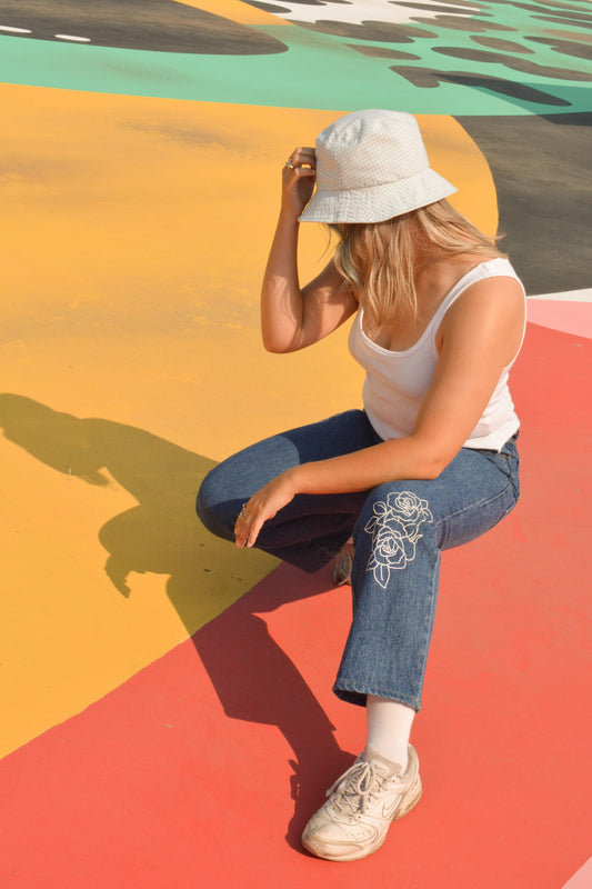 Pantalon en jeans bleu vintage à motifs de fleurs brodées à la main au Québec par l’artiste Caroline Auger de Drummondville.