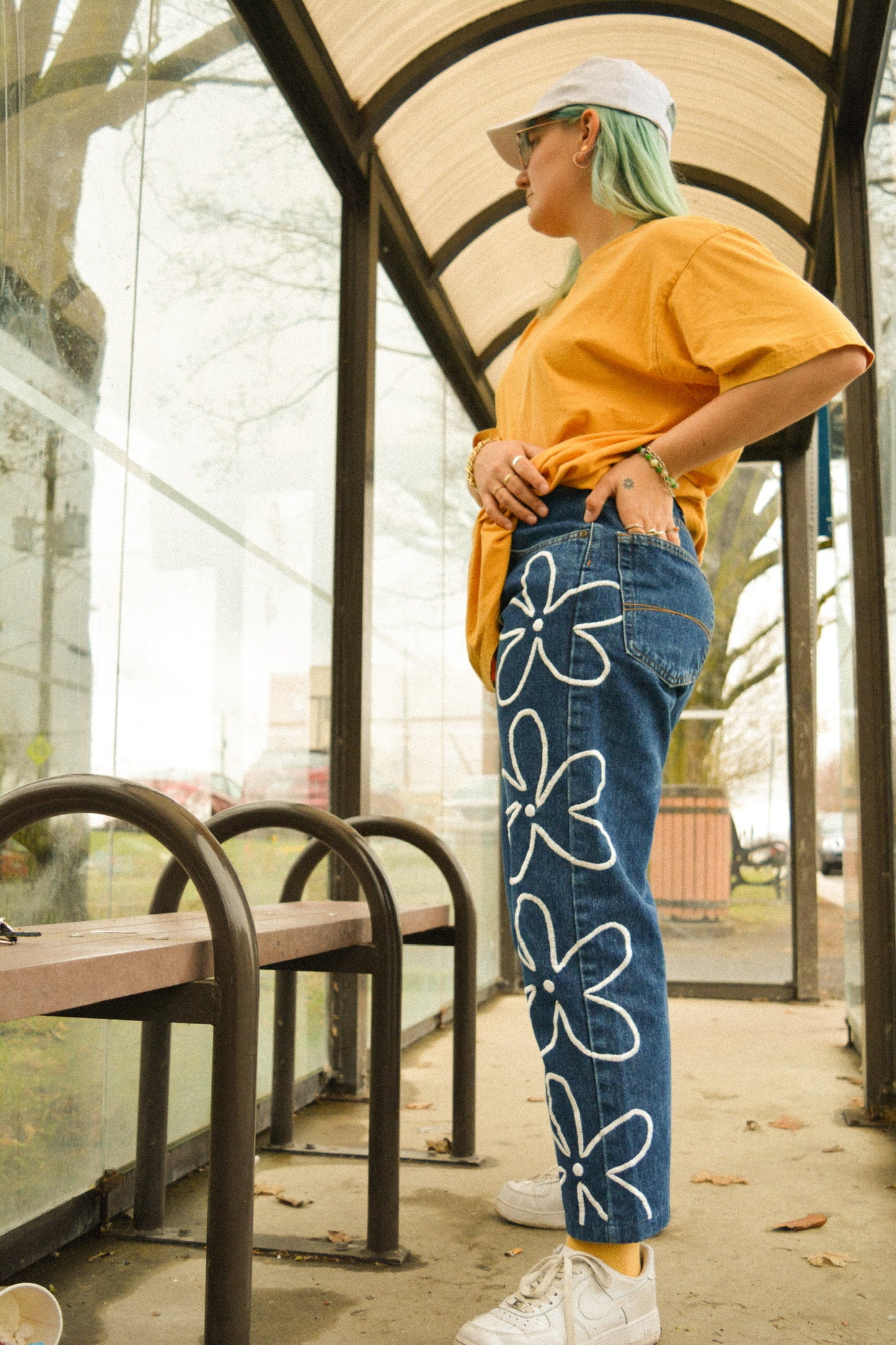 Pantalon de seconde main en jeans bleu foncé à fleurs blanches brodées à la main au Québec par l’artiste Caroline Auger