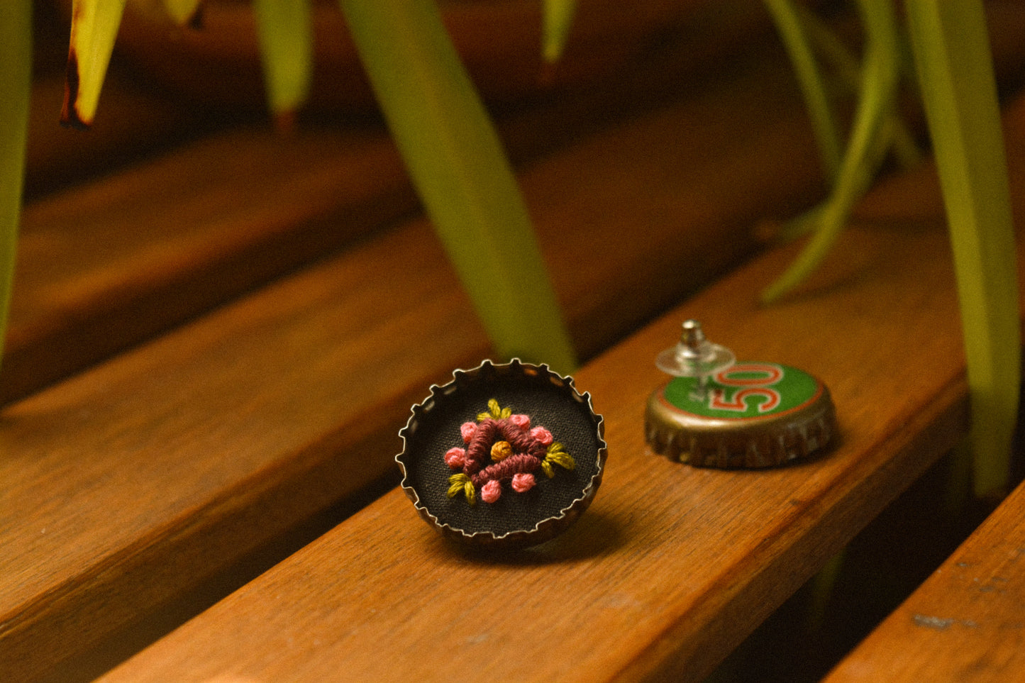 Boucles d’oreilles à fleurs brodées à la main au Québec dans des bouchons de métal recyclés par l’artiste et designer Caroline Auger.