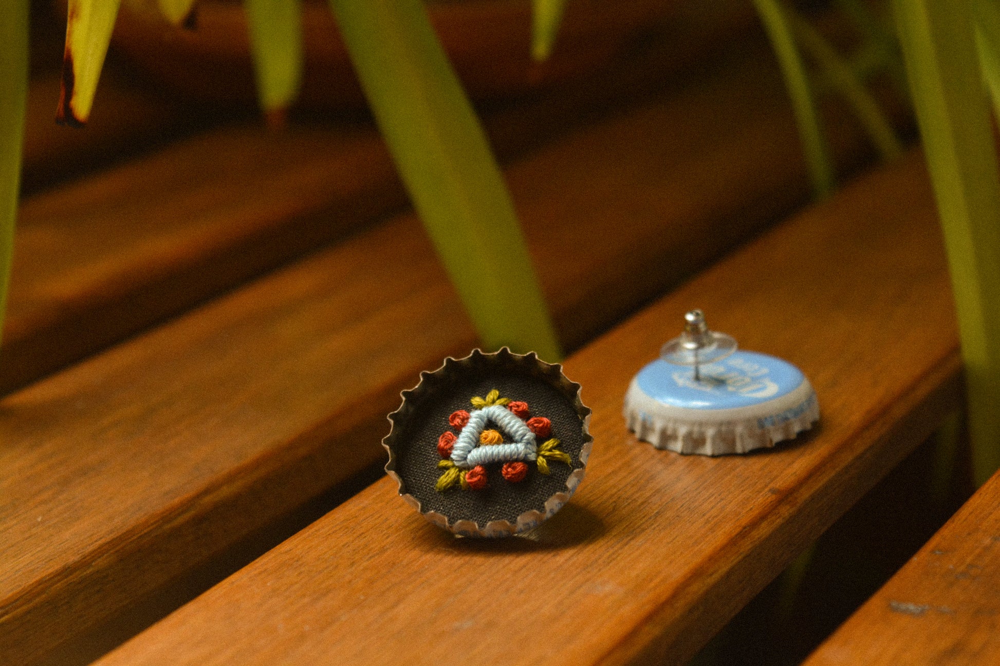 Boucles d’oreilles à fleurs brodées à la main au Québec dans des bouchons de métal recyclés par l’artiste et designer Caroline Auger.
