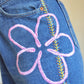 Short vintage en jeans bleu à fleurs roses brodées à la main au Québec par l’artiste et designer Caroline Auger