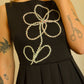 Robe noir de seconde main revalorisée par l'ajout d'un motif de fleur brodée à la main au Québec par l’artiste et designer Caroline Auger.