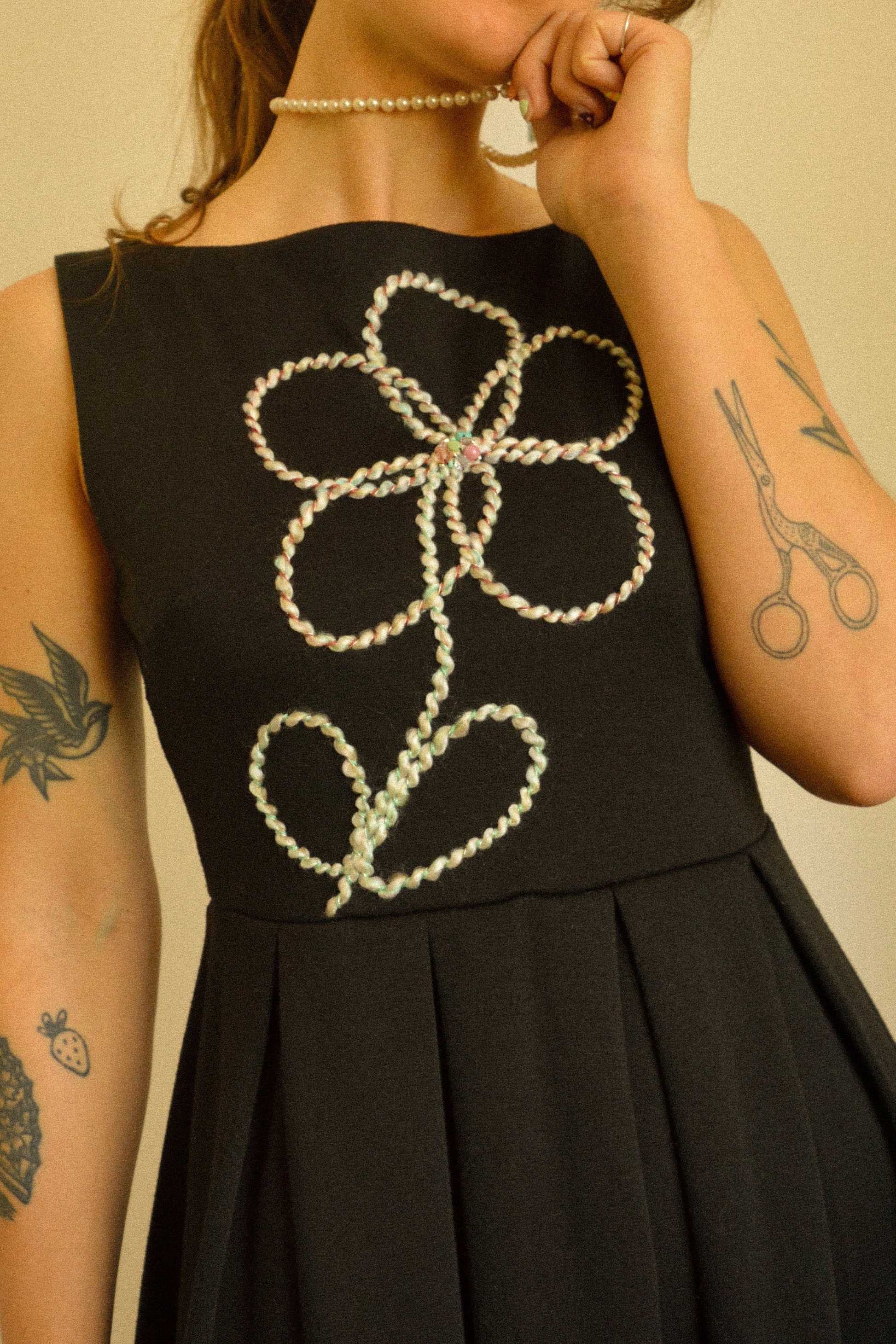 Robe noir de seconde main revalorisée par l'ajout d'un motif de fleur brodée à la main au Québec par l’artiste et designer Caroline Auger.