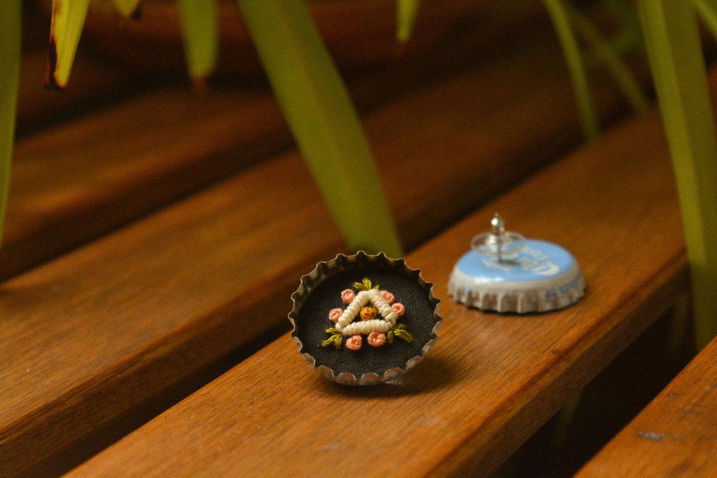 Boucles d’oreilles à fleurs brodées à la main au Québec dans des bouchons de métal recyclés par l’artiste et designer Caroline Auger.