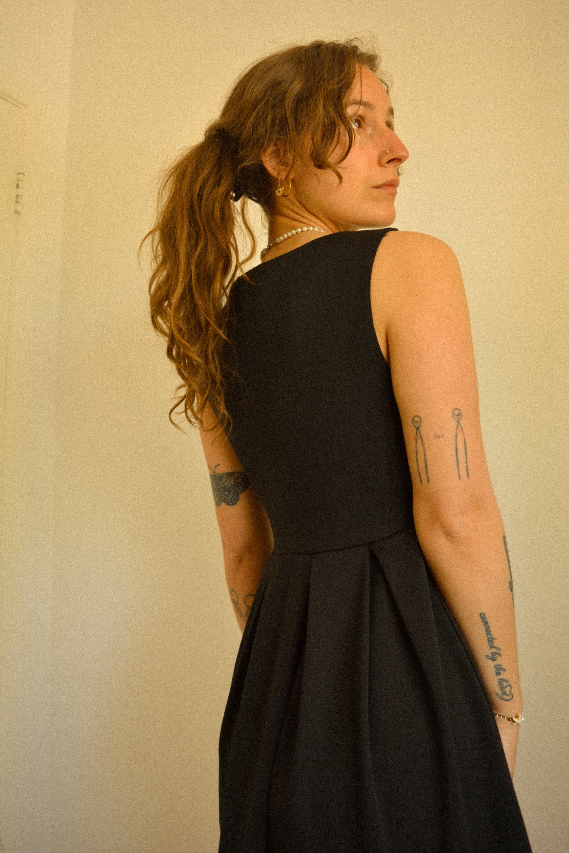 Robe noir de seconde main revalorisée par l'ajout d'un motif de fleur brodée à la main au Québec par l’artiste et designer Caroline Auger.