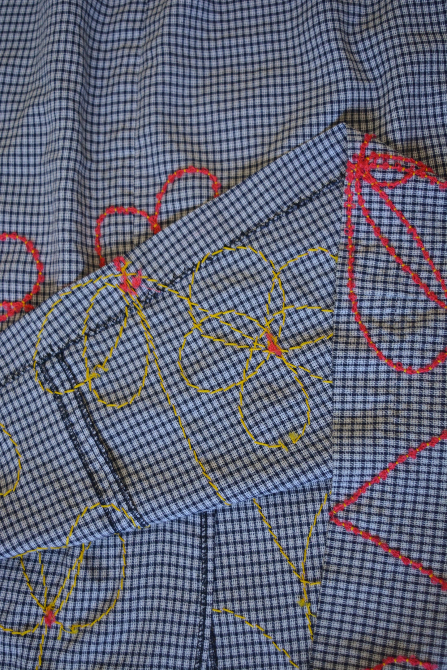 Jupe de motifs à carreaux bleu vintage de seconde main à broderie de fleurs rouge fait à la main au Québec par l’artiste Caroline Auger