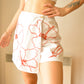 Jupe-Short vintage blanche à fleurs rouge brodées à la main au Québec par l’artiste Caroline Auger