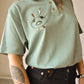 T-shirt polo vert vintage à motif d’œil old school brodé à la main au Québec par l’artiste Caroline Auger