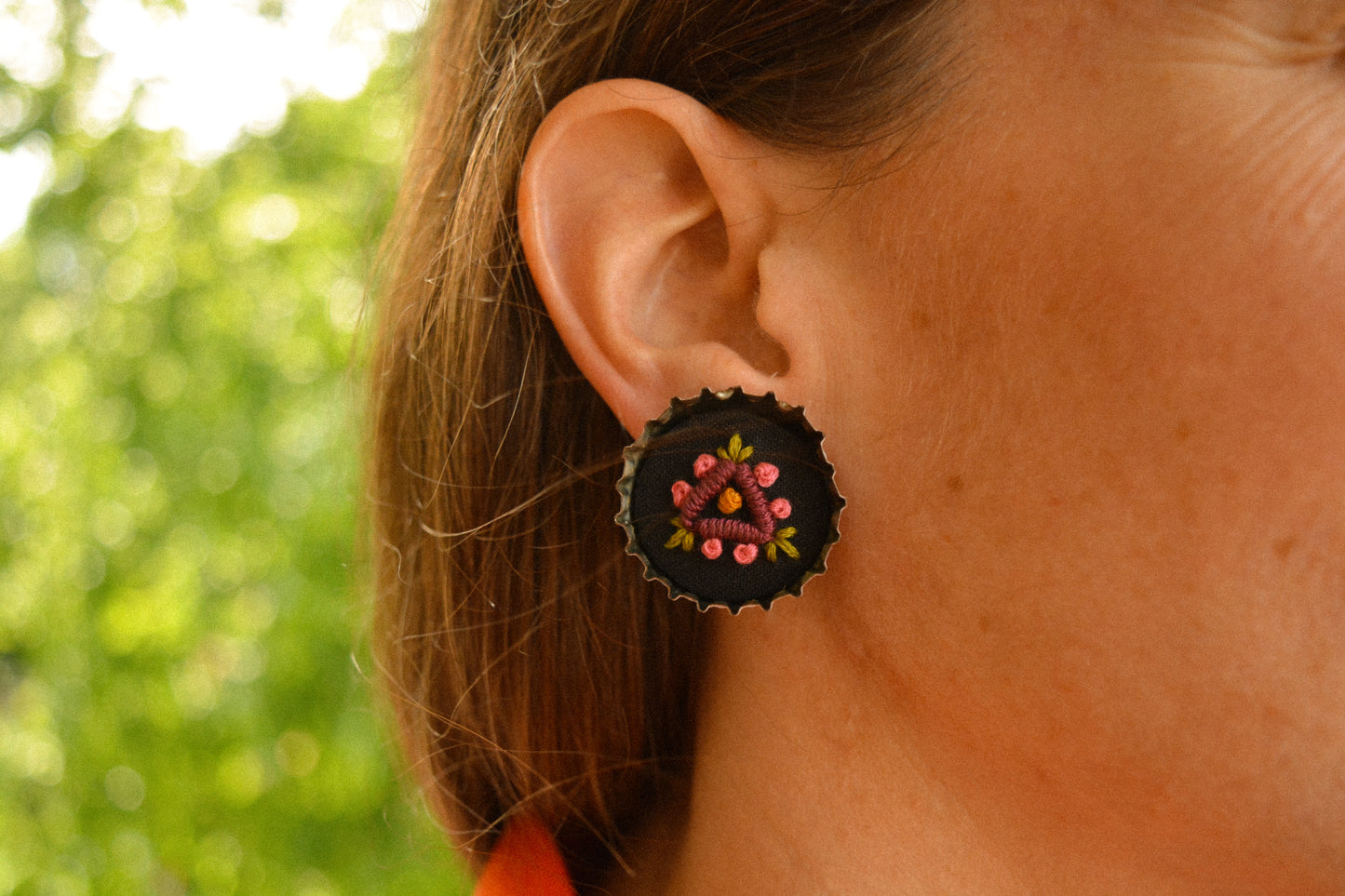 Boucles d’oreilles à fleurs brodées à la main au Québec dans des bouchons de métal recyclés par l’artiste et designer Caroline Auger.