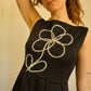 Robe noir de seconde main revalorisée par l'ajout d'un motif de fleur brodée à la main au Québec par l’artiste et designer Caroline Auger.