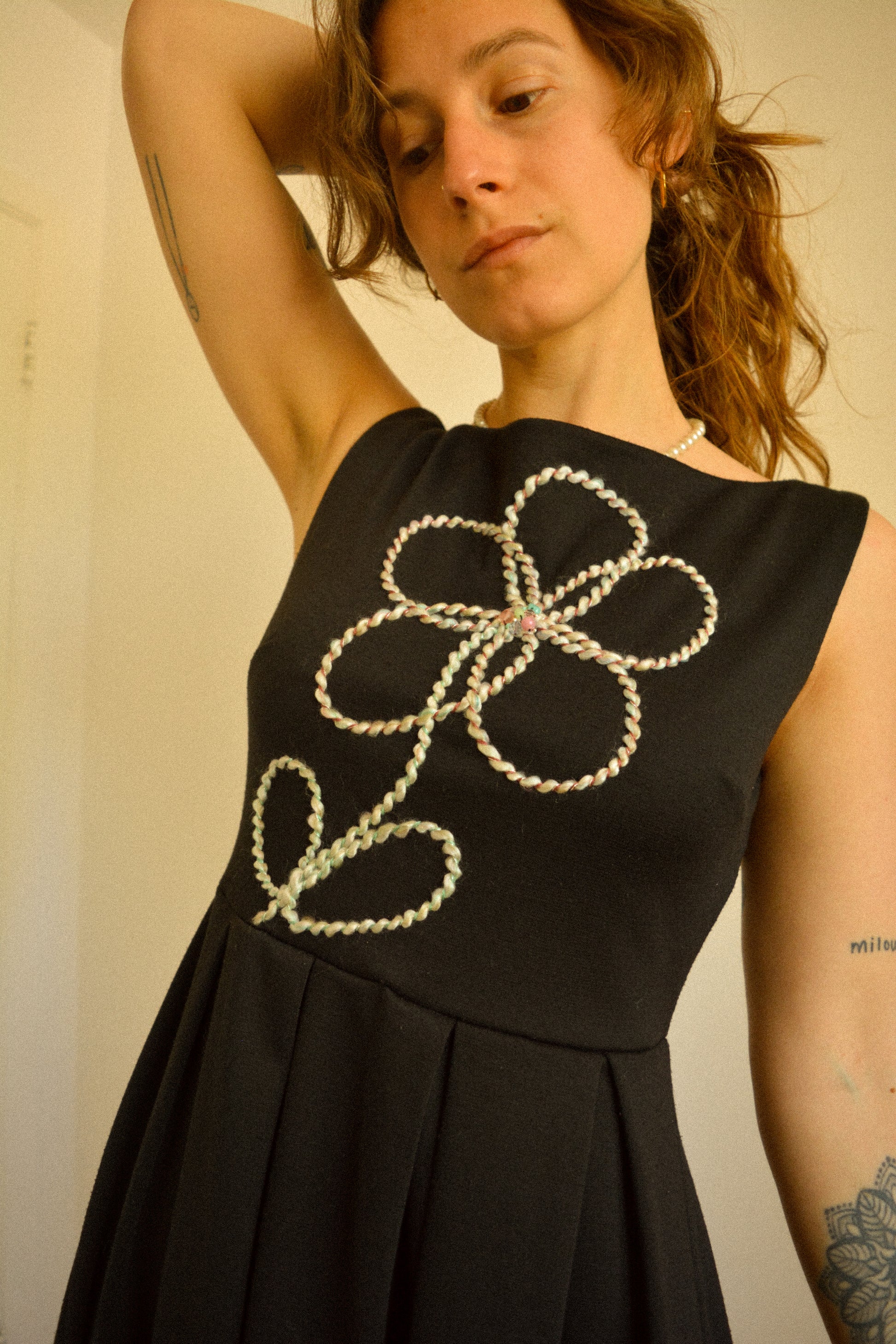 Robe noir de seconde main revalorisée par l'ajout d'un motif de fleur brodée à la main au Québec par l’artiste et designer Caroline Auger.