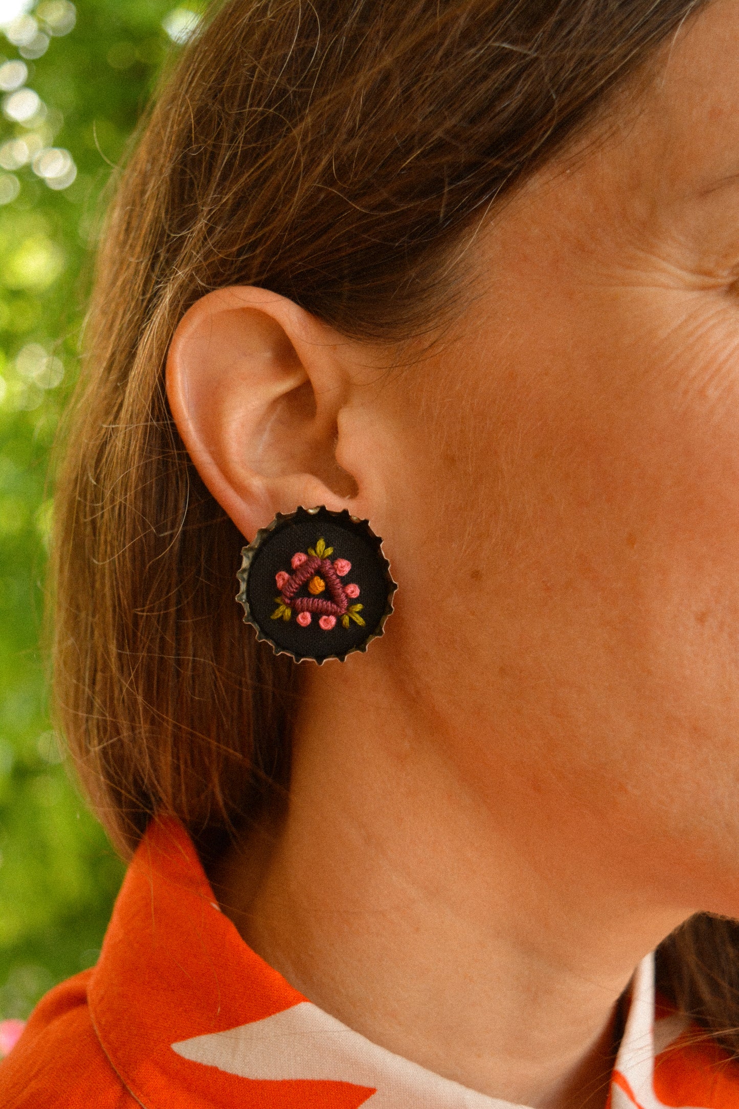 Boucles d’oreilles à fleurs brodées à la main au Québec dans des bouchons de métal recyclés par l’artiste et designer Caroline Auger.