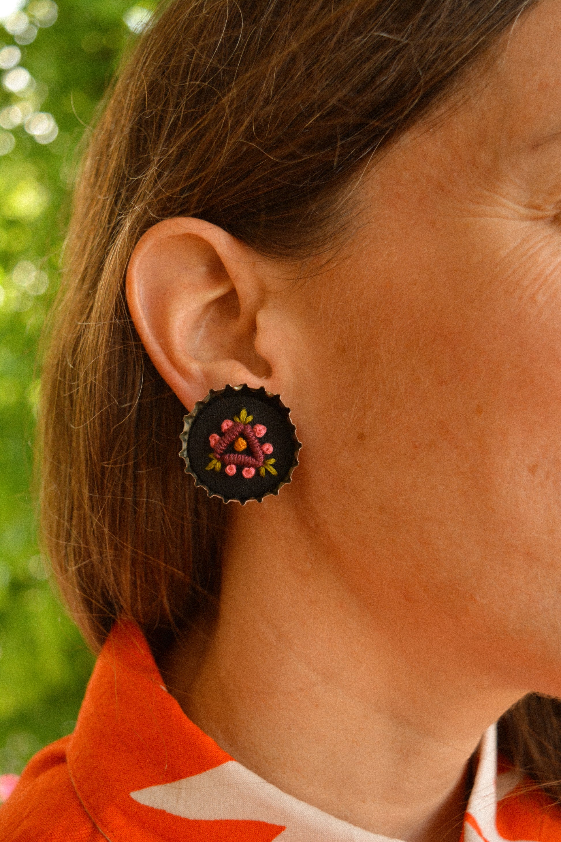 Boucles d’oreilles à fleurs brodées à la main au Québec dans des bouchons de métal recyclés par l’artiste et designer Caroline Auger.