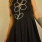 Robe noir de seconde main revalorisée par l'ajout d'un motif de fleur brodée à la main au Québec par l’artiste et designer Caroline Auger.