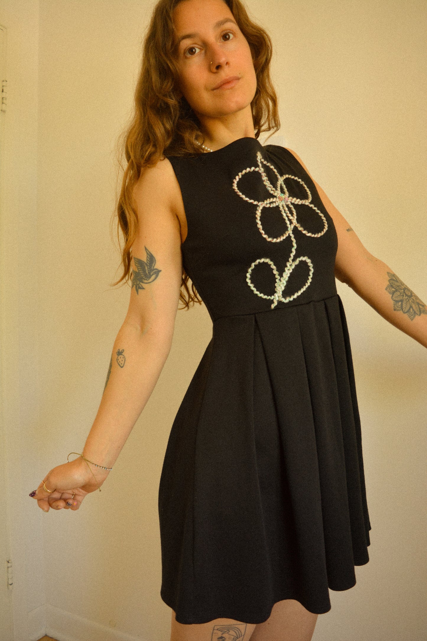 Robe noir de seconde main revalorisée par l'ajout d'un motif de fleur brodée à la main au Québec par l’artiste et designer Caroline Auger.
