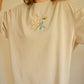 T-shirt crème à manches courtes avec motif brodé à la main au Québec par l’artiste et designer Caroline Auger