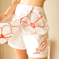 Jupe-Short vintage blanche à fleurs rouge brodées à la main au Québec par l’artiste Caroline Auger