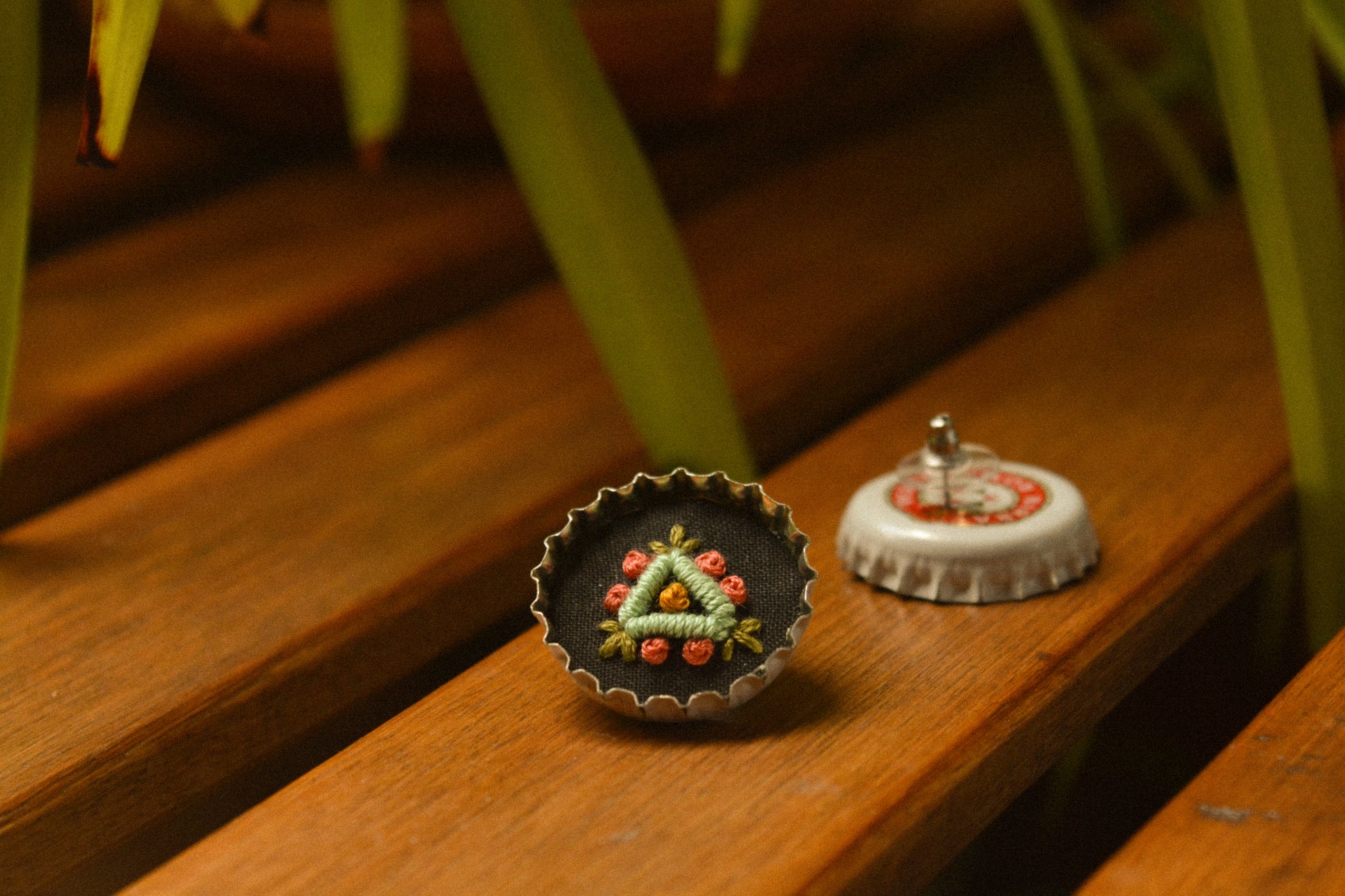 Boucles d’oreilles à fleurs brodées à la main au Québec dans des bouchons de métal recyclés par l’artiste et designer Caroline Auger.