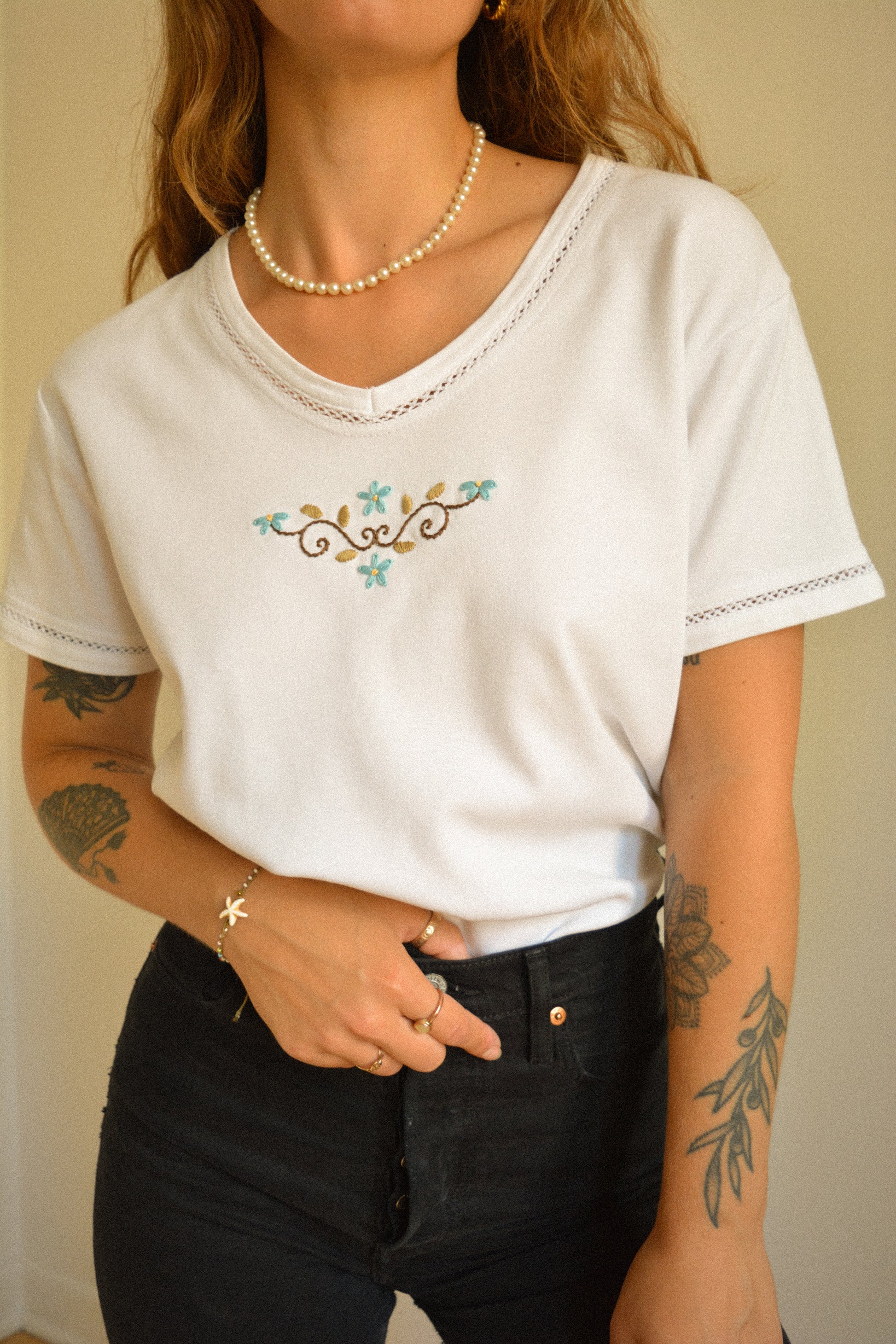 Chandail vintage à manches courtes blanc avec motif de fleurs brodées à la main au Québec par l’artiste et designer Caroline Auger