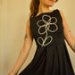 Robe noir de seconde main revalorisée par l'ajout d'un motif de fleur brodée à la main au Québec par l’artiste et designer Caroline Auger.