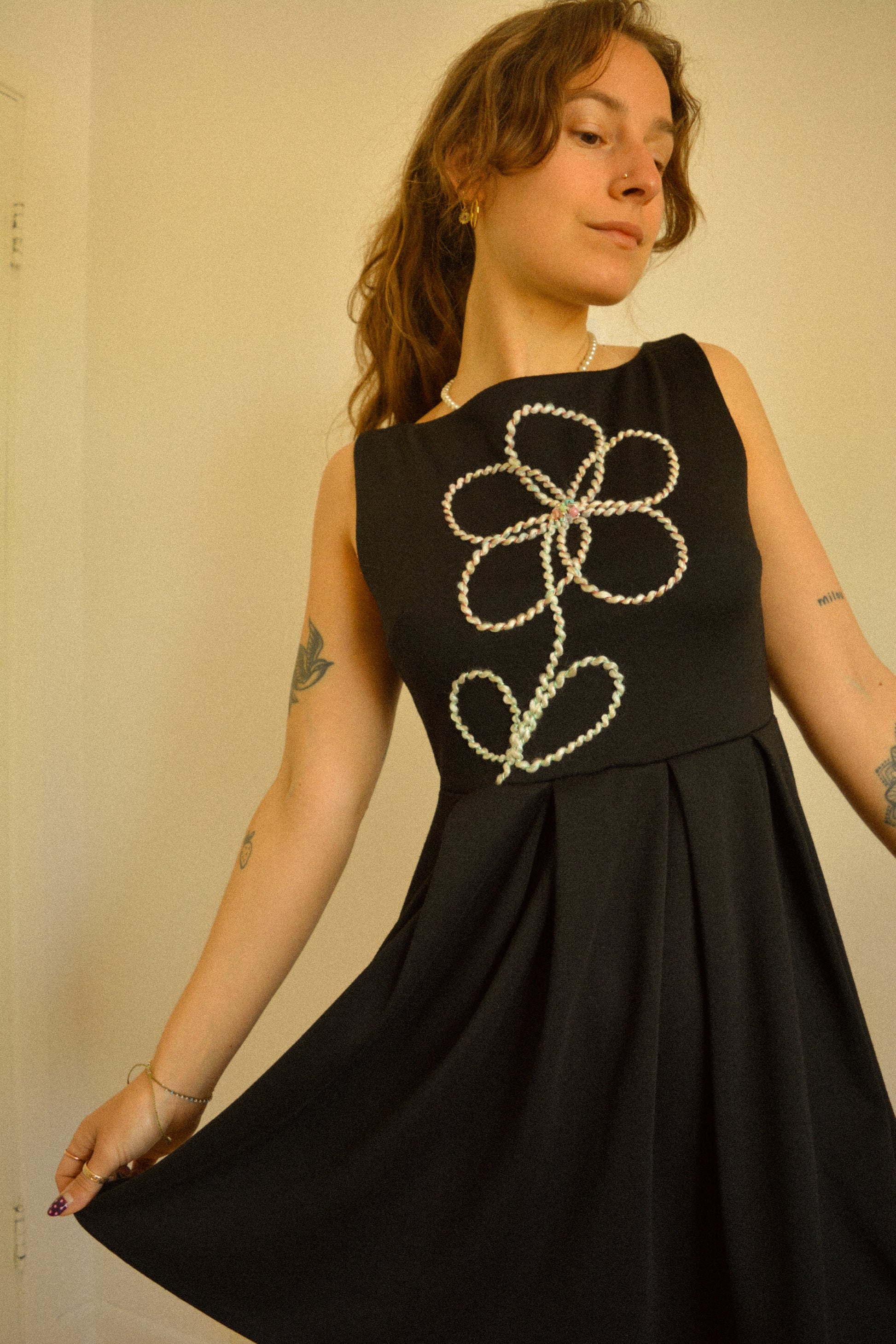 Robe noir de seconde main revalorisée par l'ajout d'un motif de fleur brodée à la main au Québec par l’artiste et designer Caroline Auger.