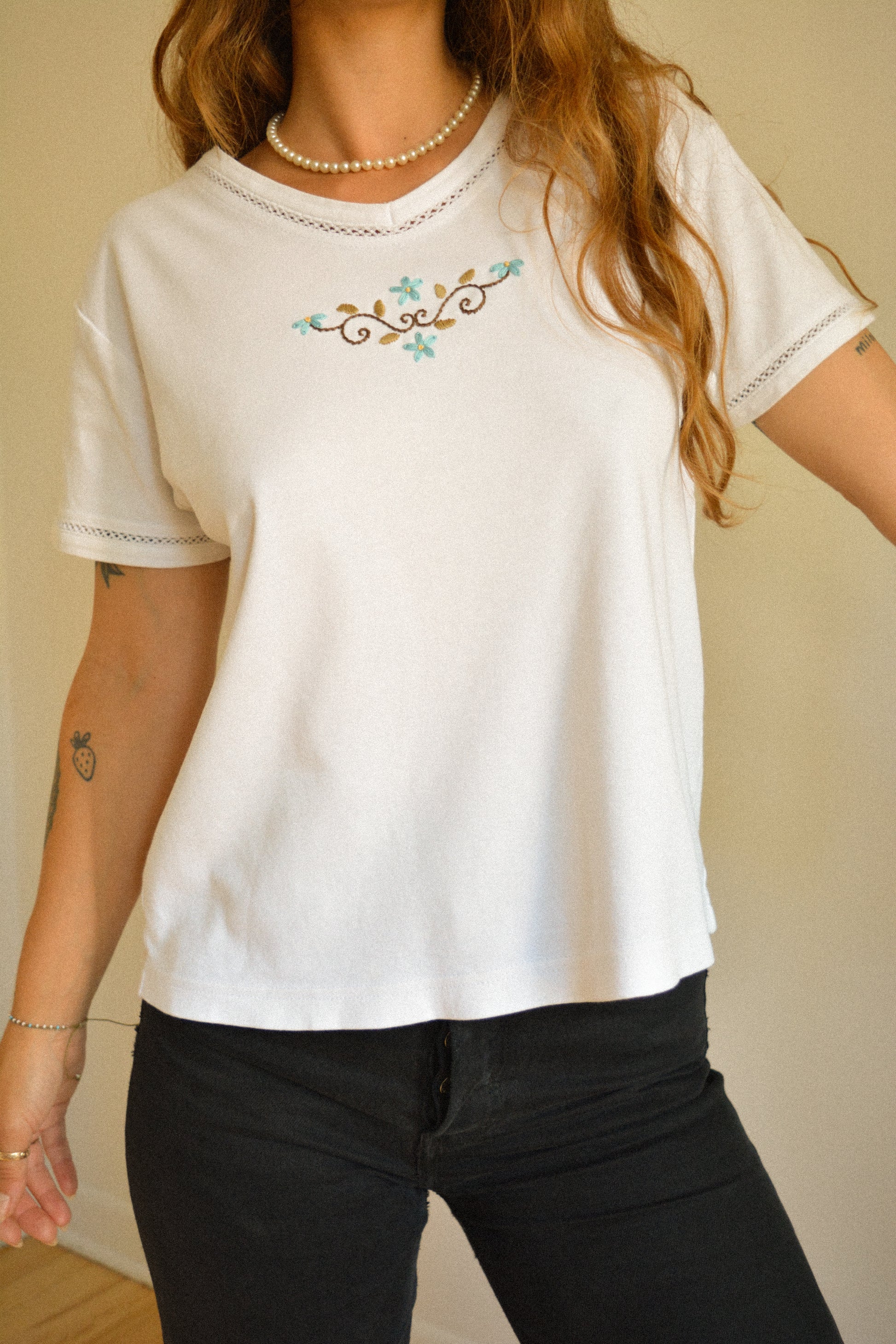 Chandail vintage à manches courtes blanc avec motif de fleurs brodées à la main au Québec par l’artiste et designer Caroline Auger