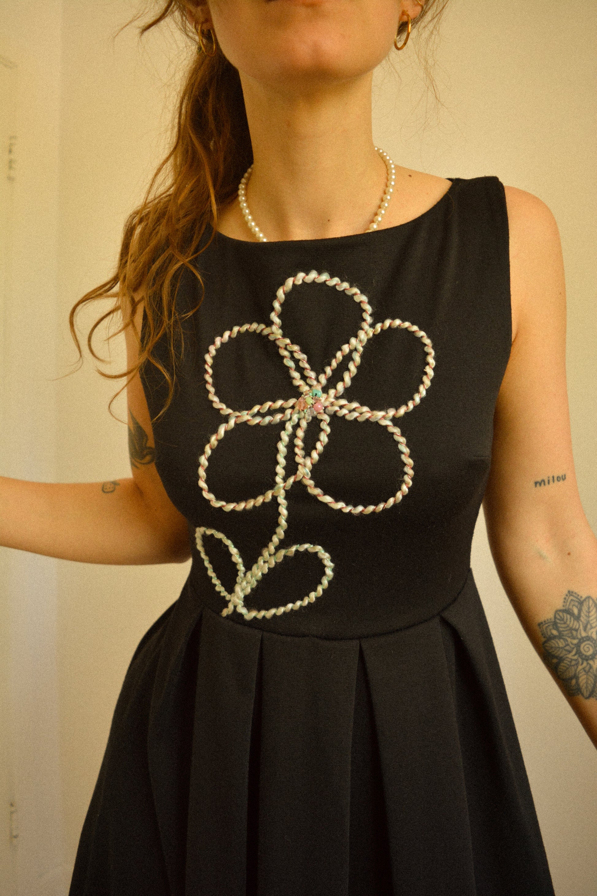 Robe noir de seconde main revalorisée par l'ajout d'un motif de fleur brodée à la main au Québec par l’artiste et designer Caroline Auger.