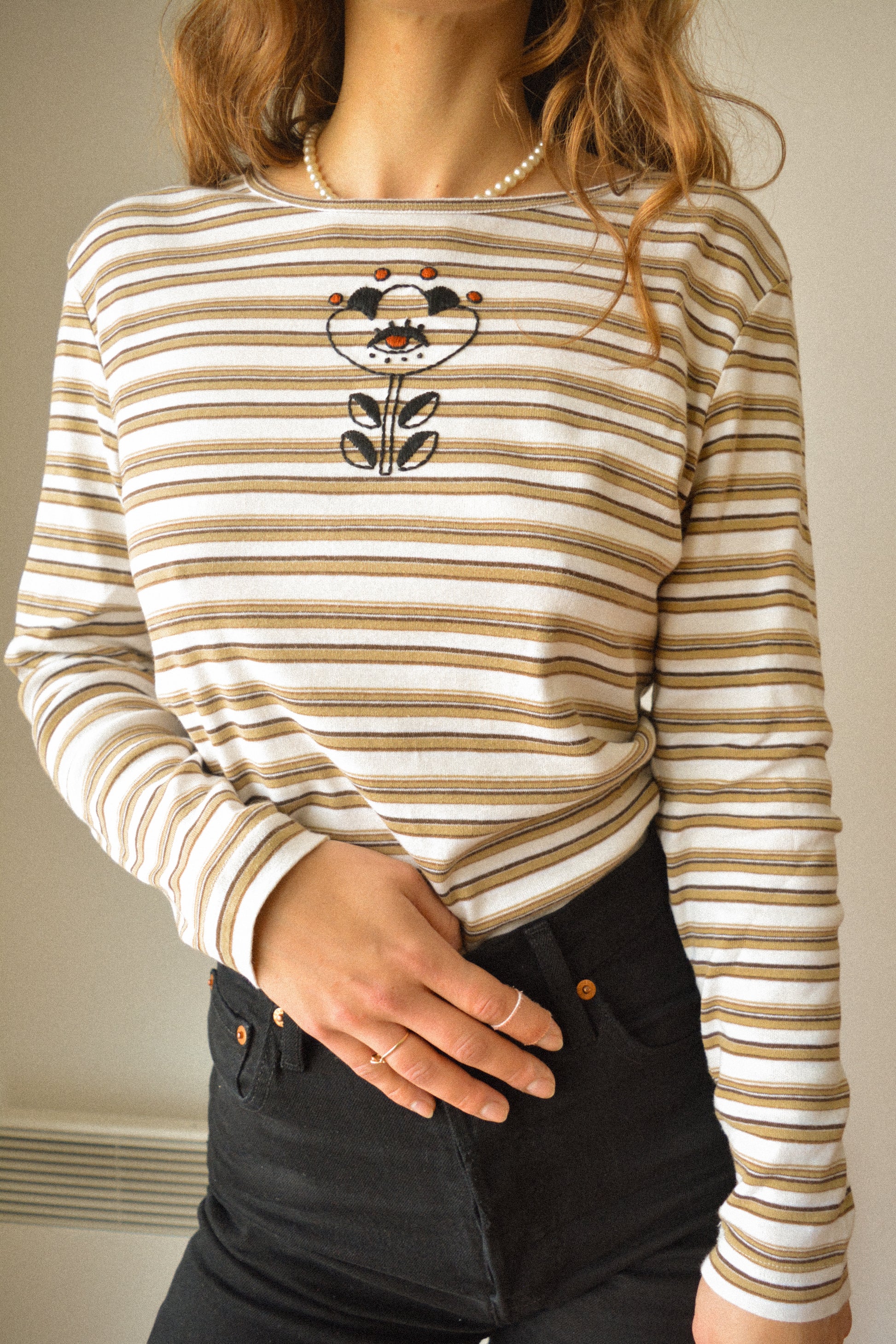 Chandail manches longues vintage rayé beige, blanc et brun à motif d’œil fleur old school brodé à la main au Québec par l’artiste Caroline Auger