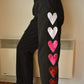 Pantalon vintage noir de seconde main avec patchs en forme de coeur fait de tissu de velours recyclés brodé à la main au Québec par l’artiste Caroline Auger