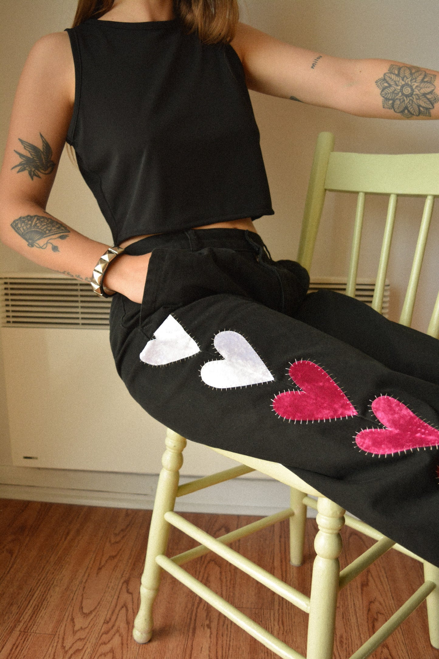 Pantalon vintage noir de seconde main avec patchs en forme de coeur fait de tissu de velours recyclés brodé à la main au Québec par l’artiste Caroline Auger