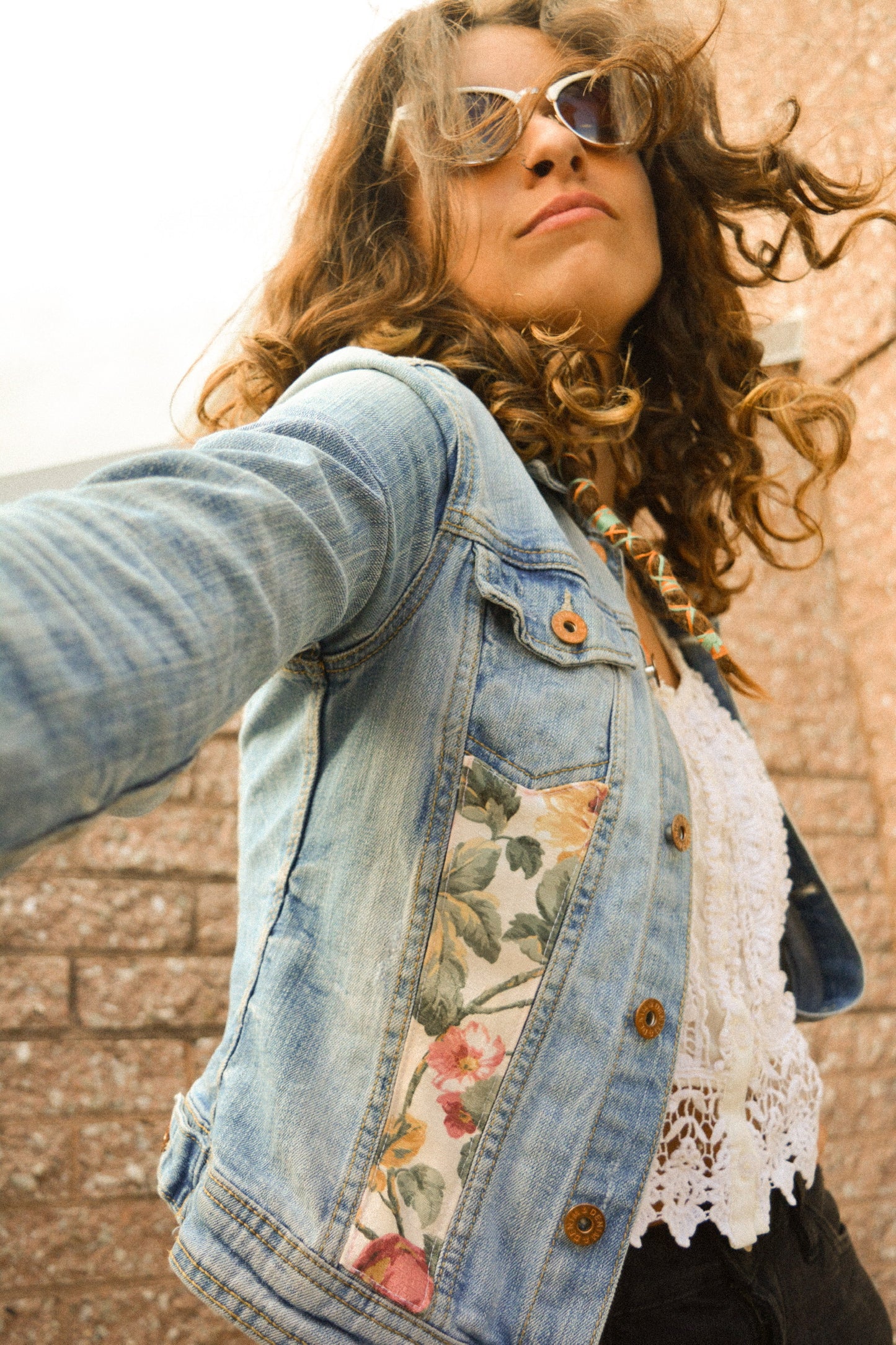 Veste de seconde main en jeans bleu à manches longues avec patch de tissu recyclé et motifs de fleurs brodées à la main au Québec par l’artiste Caroline Auger